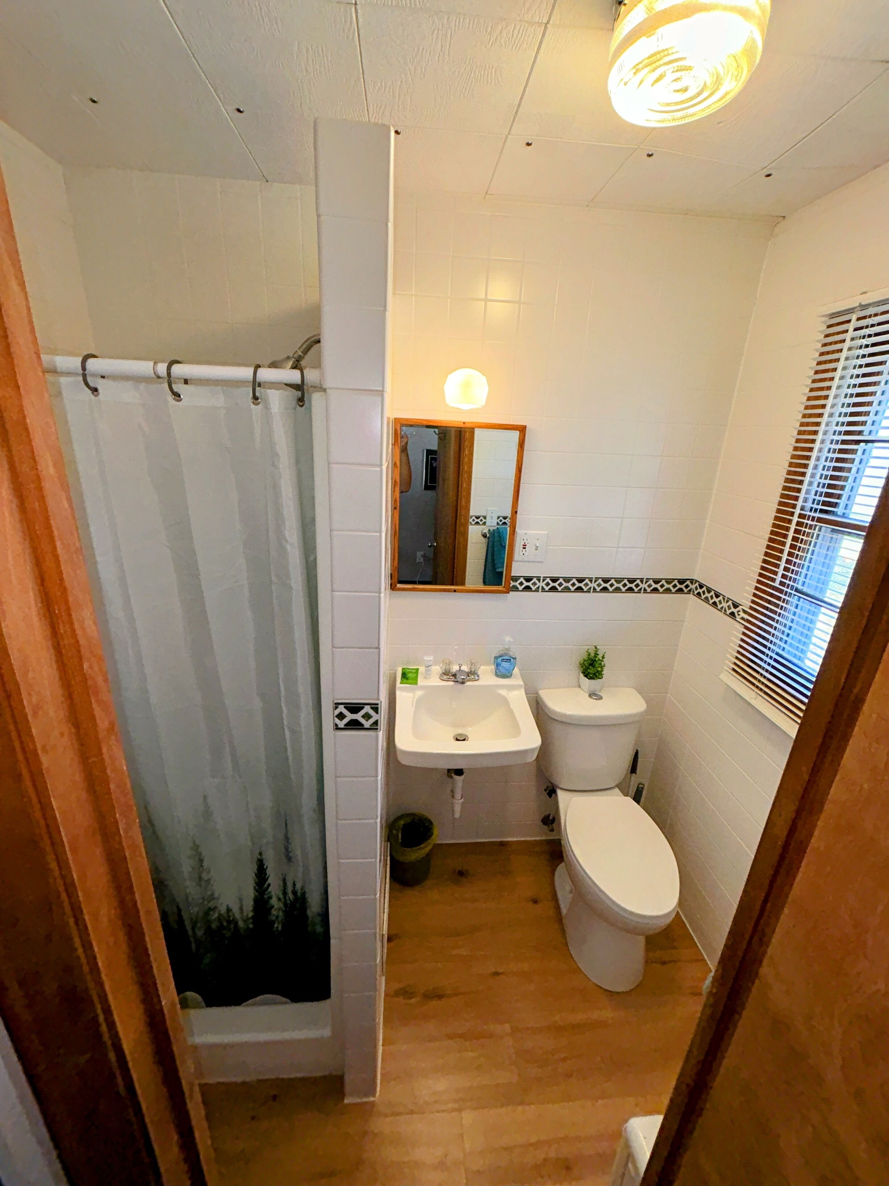 A bathroom with a shower, sink, and toilet.