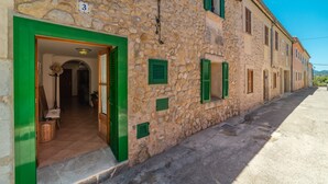 A stone building with a green door, numbered 3, and a narrow street. - Holiday Home Villa Ca Na Campins with Mountain View, Pool, Terraces & Wi-Fi (Campanet)