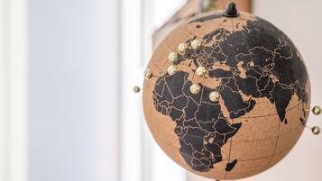Een wereldbol met een gebarsten oppervlak en gouden pinnen, gemonteerd op een voet.