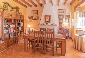 A dining area with wooden furniture, a fireplace, and framed pictures on the walls. - Rural Holiday Home 'Santa Ana' with Pool & Wi-Fi (Marchena)