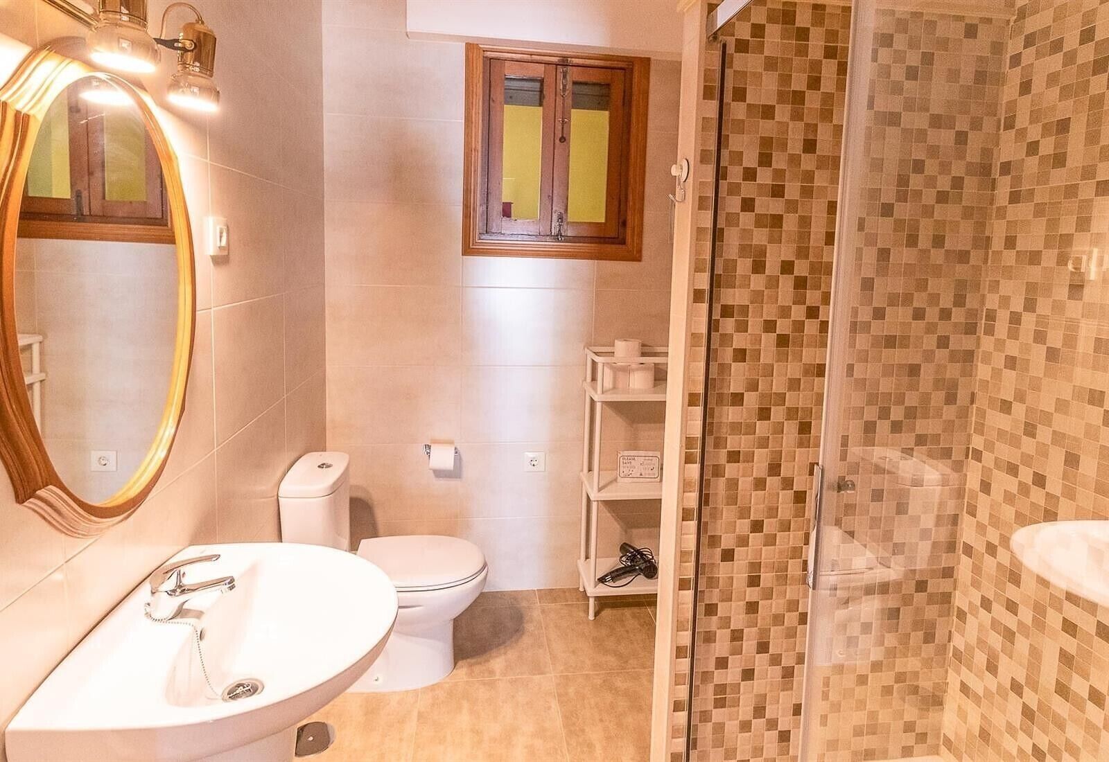 A bathroom with a sink, toilet, and shower.