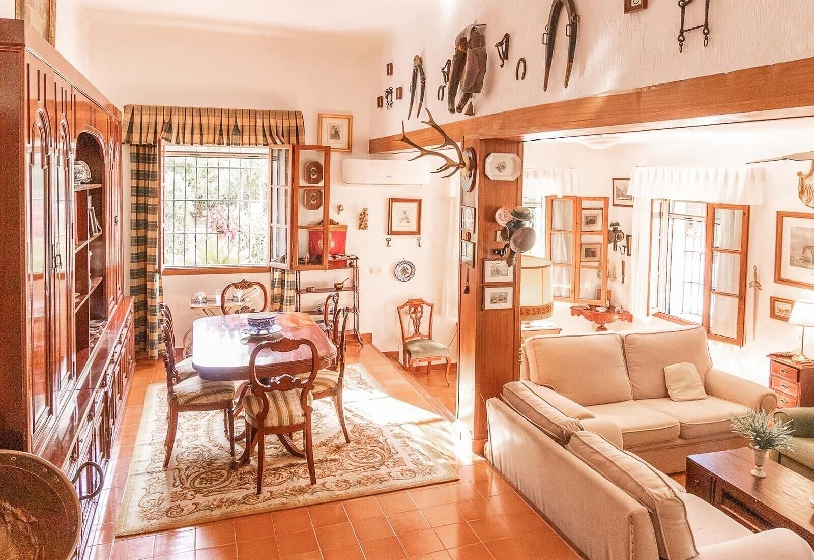 Una sala de estar acogedora con un sofá, una mesa de comedor con sillas y una zona de cocina con ventanal.