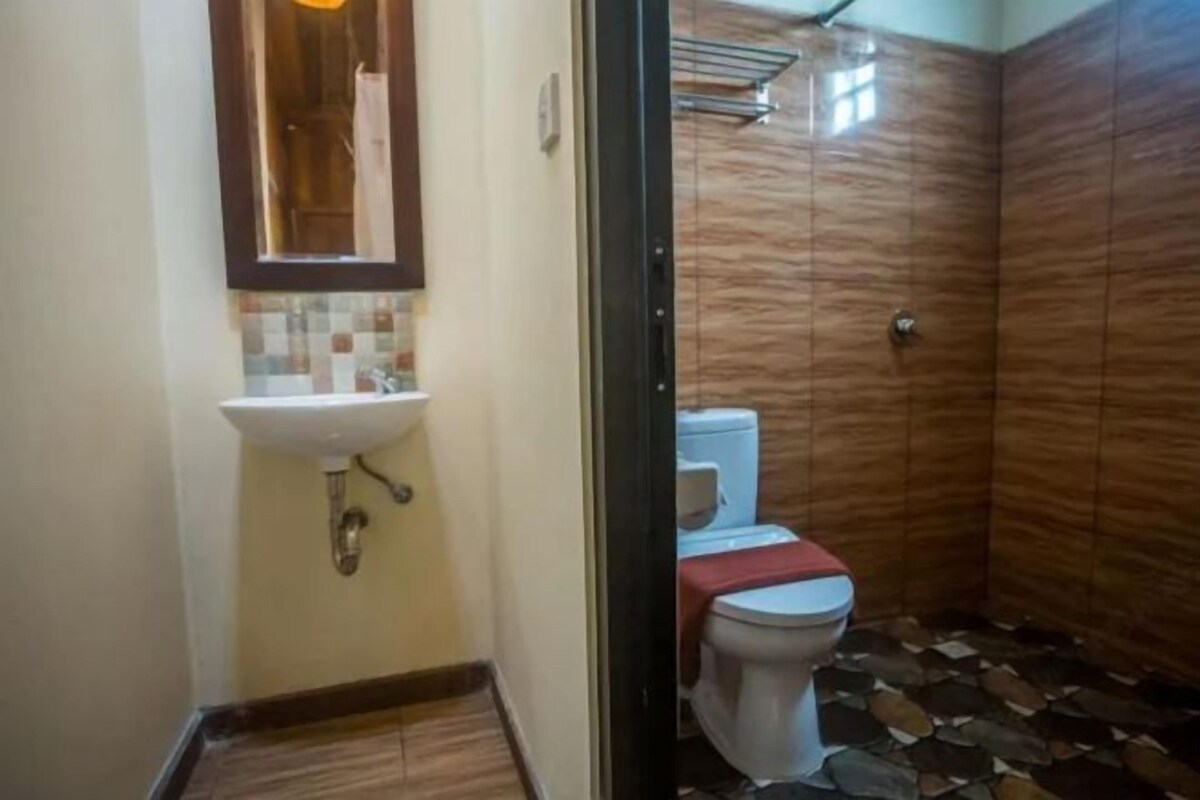 A bathroom with a tiled floor, a sink, and a toilet.