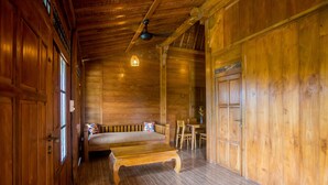 A wooden interior with a sofa, a wooden table, and a ceiling fan.