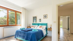 Camera da letto con un letto, una finestra e vista sul verde.