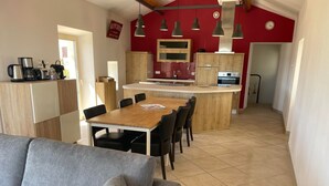 A modern kitchen with wooden cabinets, a central island, and pendant lighting.