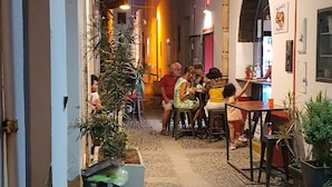 A cobblestone alley with outdoor seating, plants, and a building with an archway. - Holiday Home "Villa Adriana" with Terrace & Wi-Fi (Pantelleria)