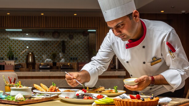 A chef serving food at a restaurant. - Golden Tulip Jalandhar (Jalandhar)