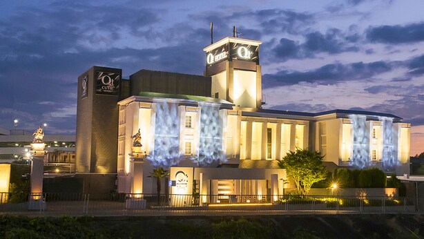 Un hotel con una torre destacada y una fachada con diseños iluminados.
