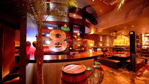 A bar area with a wooden barrel, a large number 8 decoration, and a bar counter with stools. - Keikyu EX Hotel Sapporo (Sapporo)