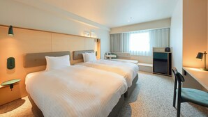 A hotel room with two beds, a desk, a chair, a TV, and a window with curtains. - Keikyu EX Hotel Sapporo (Sapporo)