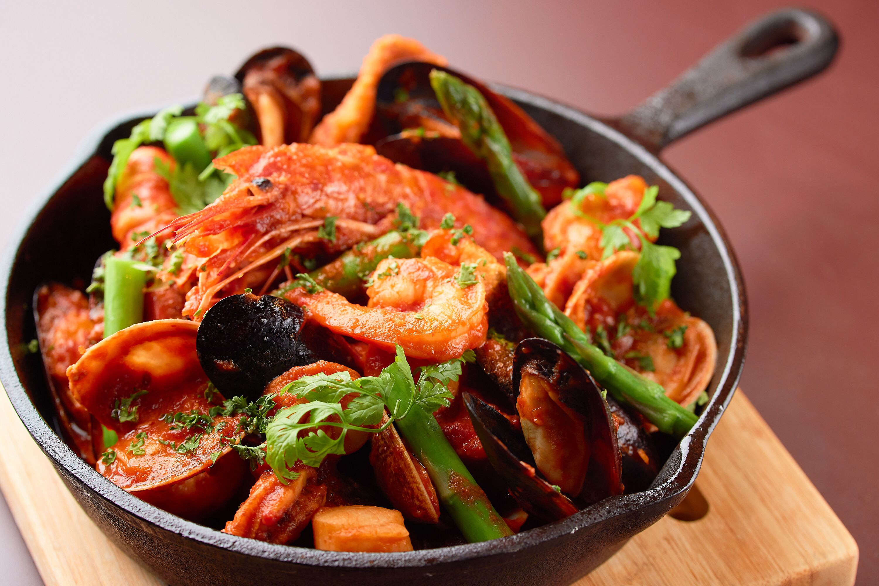 Una sartén con mariscos y verduras.