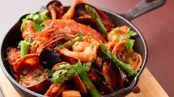 Una sartén con mariscos y verduras.