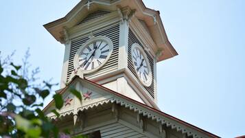 A clock tower with two large clocks, a star decoration, and a clear sky in the background.