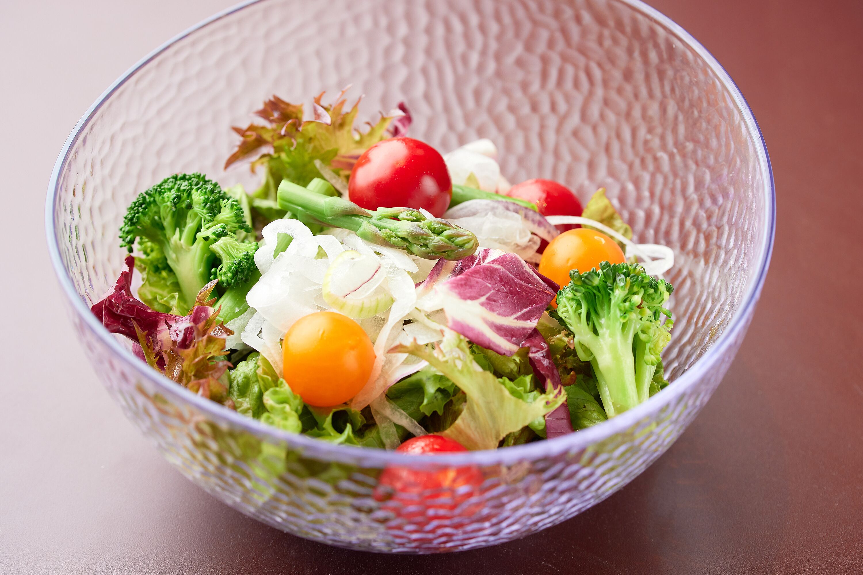 A clear view of a salad bowl with various vegetables.