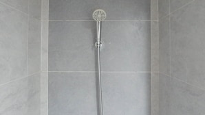 A shower with a handheld showerhead and a long hose. - Exclusive And Comfy Studio Room Apartment At Taman Melati Surabaya (Surabaya)