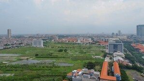 A cityscape with a mix of residential and commercial buildings, a prominent church, and surrounding green areas. - Cozy And Compact Studio Apartment At Taman Melati Surabaya (Surabaya)