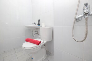 A modern bathroom with a toilet, sink, and shower. - Luxurious Studio At Patraland Urbano Apartment (Bekasi)