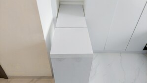 A modern, minimalist room with a clean, white color scheme and a marble floor. - Homey And Warm Studio At Sky House Bsd Apartment (Pagedangan)