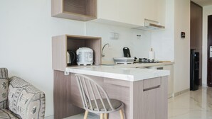 A compact kitchen with a built-in island, a coffee machine, and a sink. - Homey And Cozy Living 2Br At Sky House Bsd Apartment (Pagedangan)