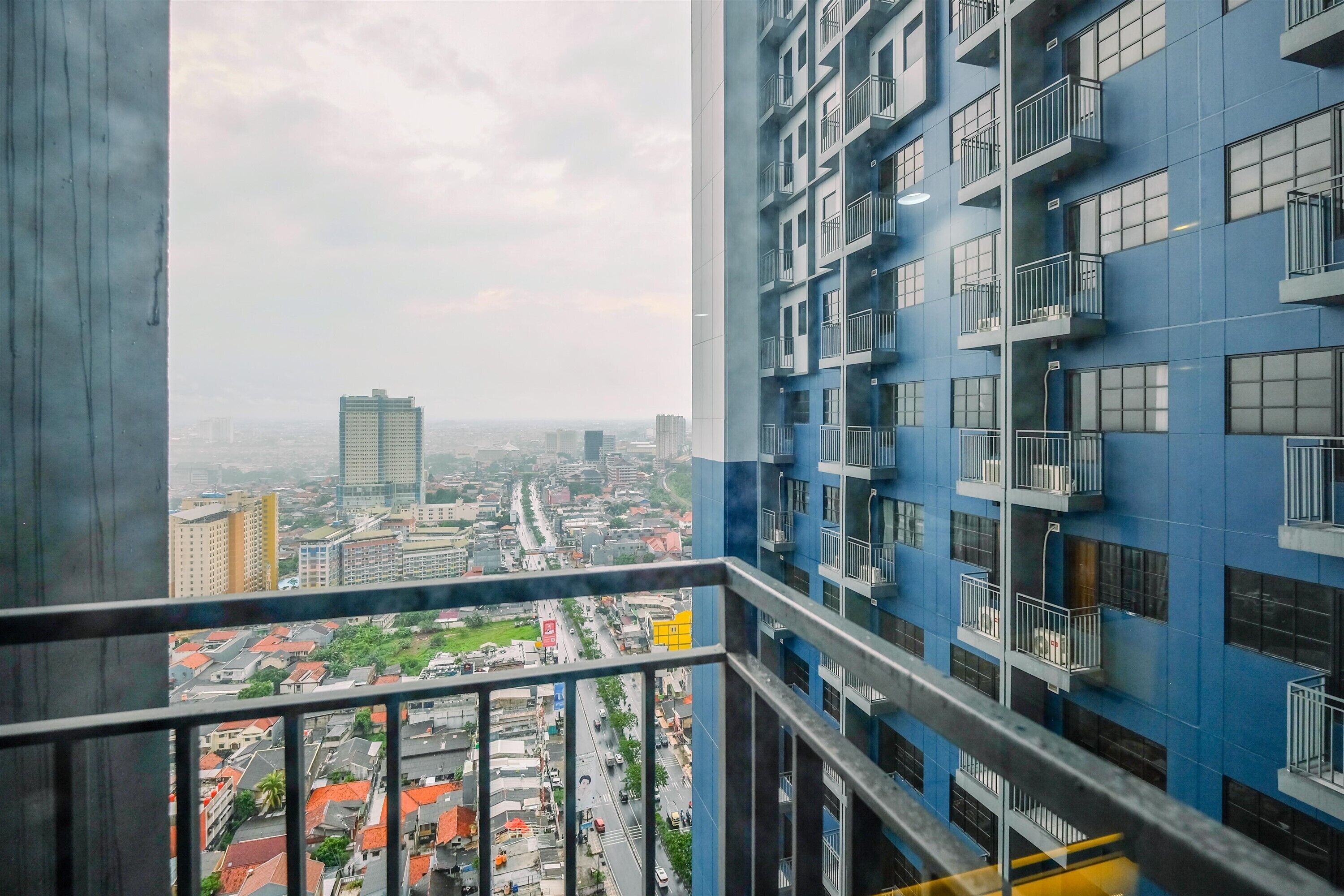 Ein Hochhaus mit mehreren Balkonen und Blick auf eine Stadtlandschaft.