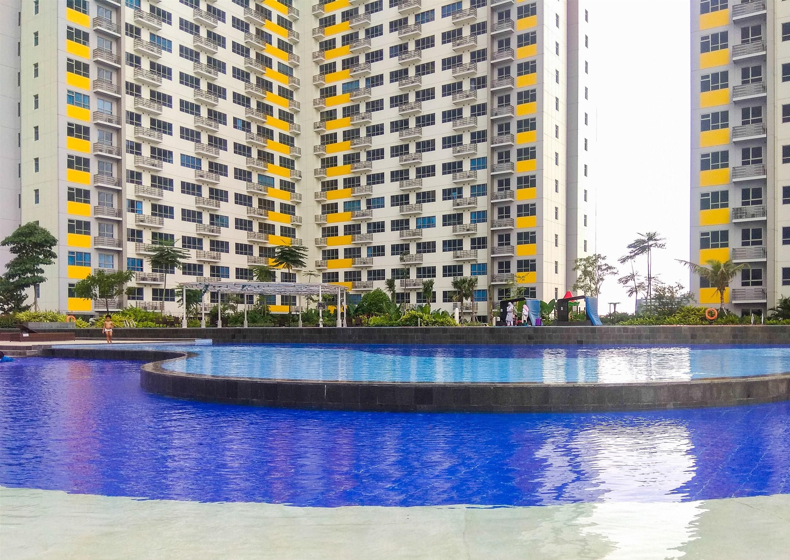 A residential building with multiple balconies and a swimming pool.