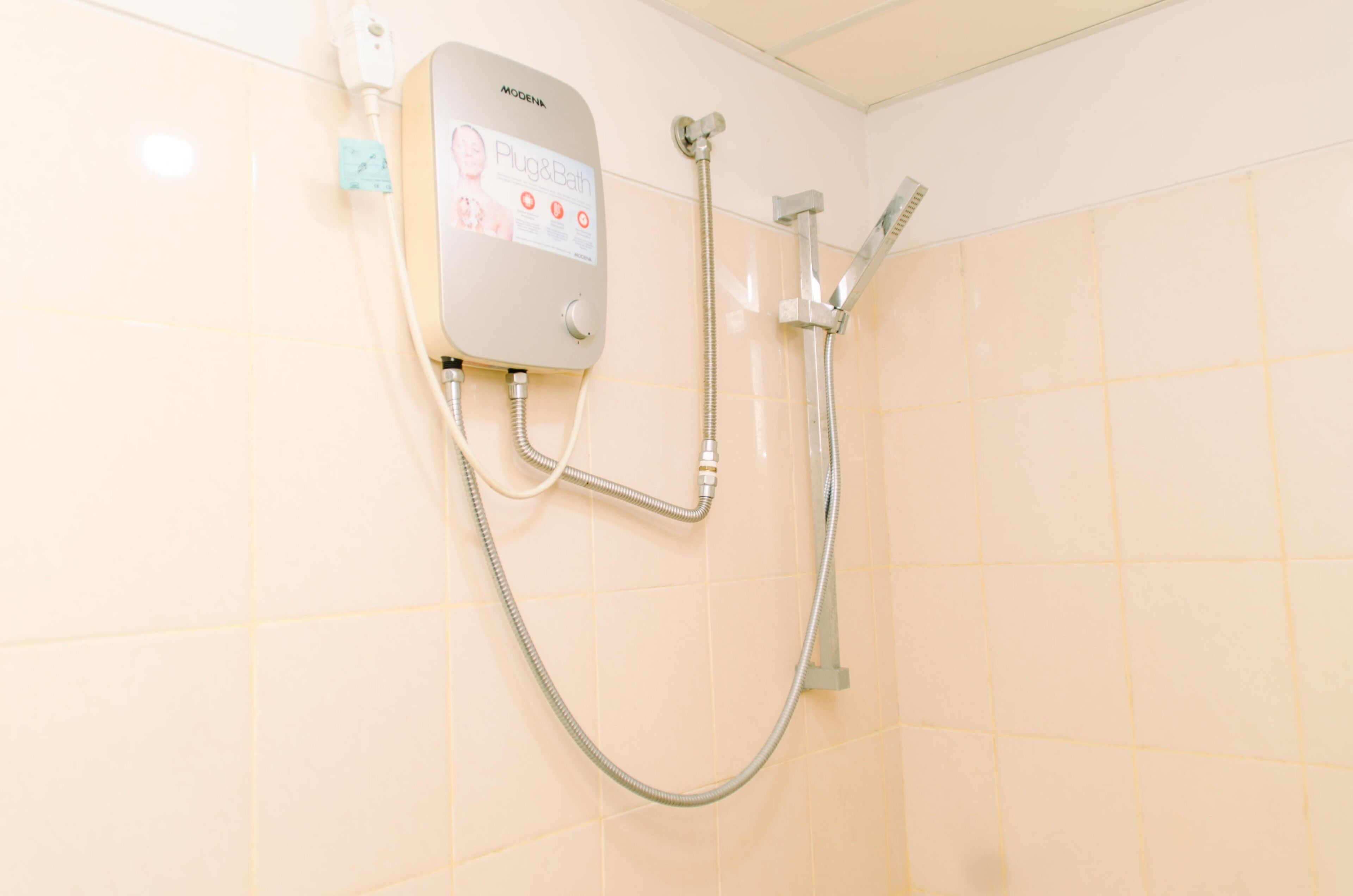 Een badkamer met een inbouwdouche, een handdouche en een bedieningspaneel.