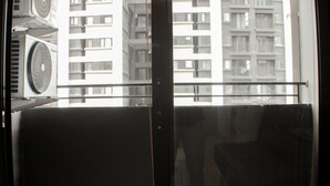 A view from a balcony with a metal railing, overlooking a high-rise building with multiple balconies. - Nice And Spacious 3Br At Meikarta Apartment (Cikarang)