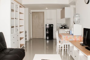 A compact living space with a kitchenette, a dining area, and a seating area.