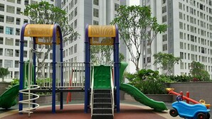 A playground with a slide, climbing structures, and a swing set. - Nice And Comfort Studio At M-Town Residence Apartment (Gading Serpong)