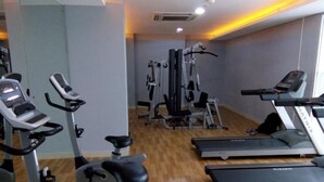 A gym with treadmills, elliptical machines, and weight equipment. - Minimalist And Homey 1Br At Bassura City Apartment (Jakarta)