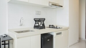 Una cocina moderna con armarios blancos, un lavaplatos integrado, un lavavajillas negro y una estufa a gas.