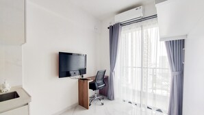 Une chambre d’hôtel moderne dotée d’une télévision à écran plat, d’un bureau en bois, d’un fauteuil de bureau noir, d’une grande fenêtre avec des rideaux et d’un sol en marbre.