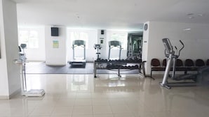 Een sportschool met loopbanden, gewichten en trainingsapparatuur.