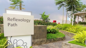 A sign labeled "Reflexology Path" in a landscaped area with greenery and a pathway. - Nice And Comfy Studio At Springlake Summarecon Apartment (Bekasi)