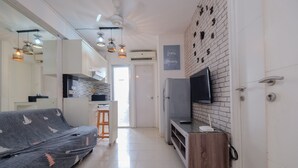 A modern kitchen with a built-in oven, a refrigerator, and a wooden countertop. - Comfort And Warm 2Br At Bassura City Apartment (Jakarta)