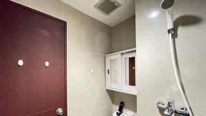 Un baño con inodoro, ducha y armario.
