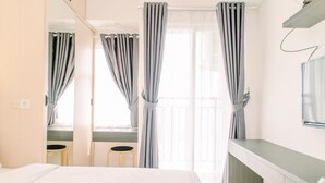 Una habitación de hotel con una cama, un escritorio y un televisor.