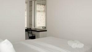 Een hotelkamer met een bed, een bureau en een stoel.