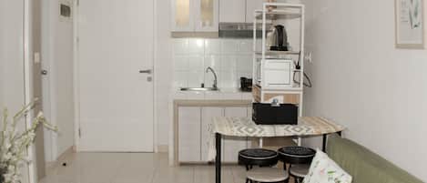 A compact kitchen with a dining area, a sofa, and a small table with chairs.