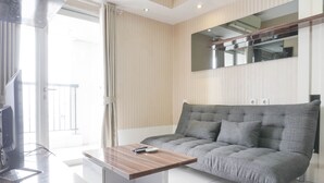 A modern living room with a grey sofa, a wooden coffee table, and a flat-screen TV.