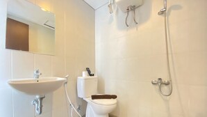 Un baño moderno con lavamanos, inodoro y ducha.