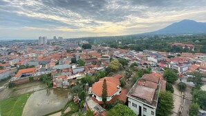 Un paisaje urbano con un río, edificios y una montaña al fondo.