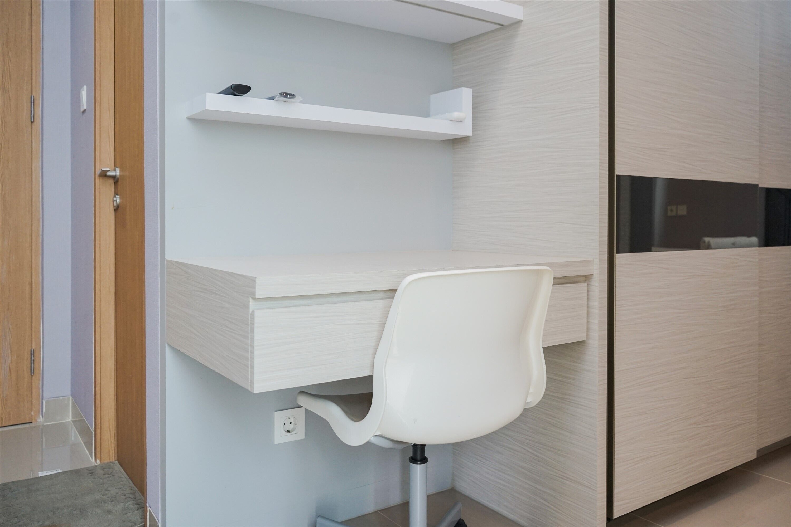 Une salle de bain moderne avec un meuble-lavabo blanc, une chaise blanche et un meuble en bois.