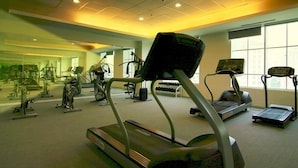Un gimnasio con cintas de correr, elípticas y pesas sueltas.