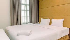 Una habitación de hotel con una cama grande, un cabecero de madera y una ventana con cortinas.