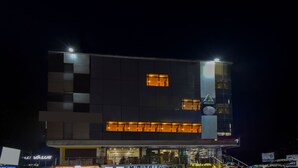 A modern building with a flat roof, large windows, and a visible entrance. - Treebo Sky Point (Jalpaiguri)
