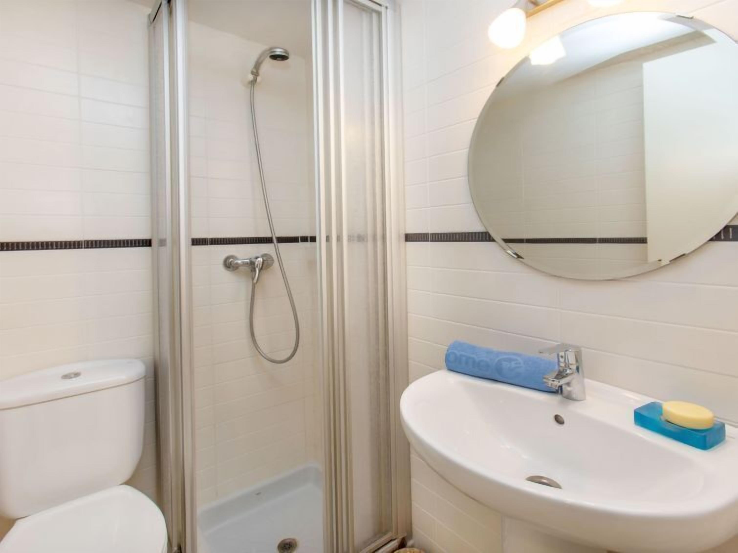 Un baño con ducha, inodoro y lavamanos.