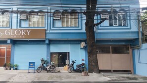 A hotel named "GLORY HOTEL" with a blue facade, two motorcycles parked in front, and a 'NO PARKING' sign. - Glory Hotel Cubao (Quezon City)