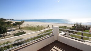 Un balcon avec vue sur une plage et la mer.